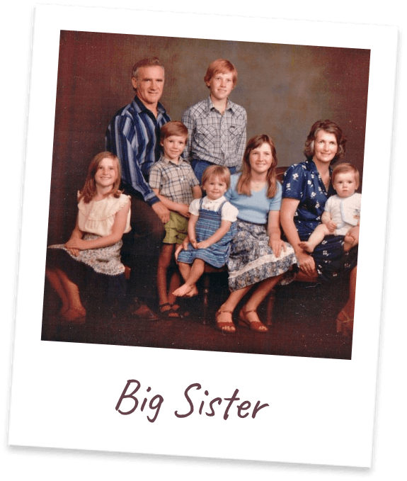 Big Sister. A 1970s studio portrait of the family of ten, seated against a dark backdrop.