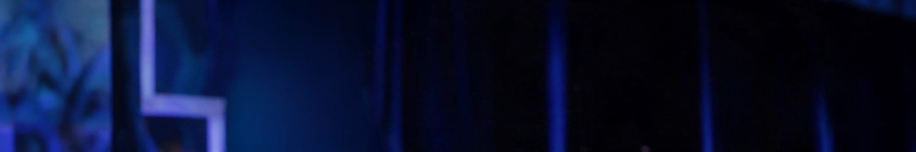 Darkened stage set of vertical truss framework lit in deep blue