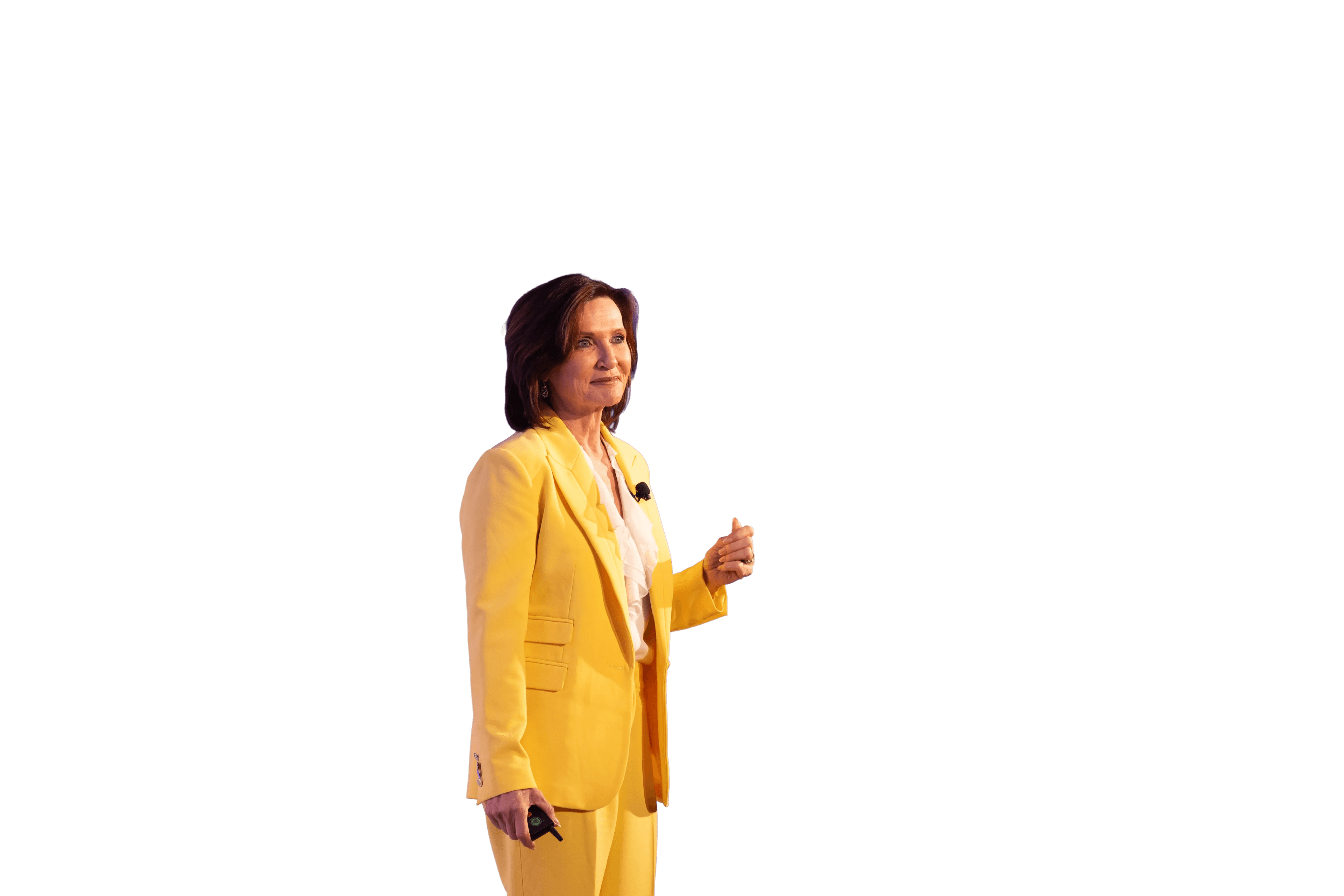 Margie Warrell in a bright yellow blazer, speaking with her hand raised